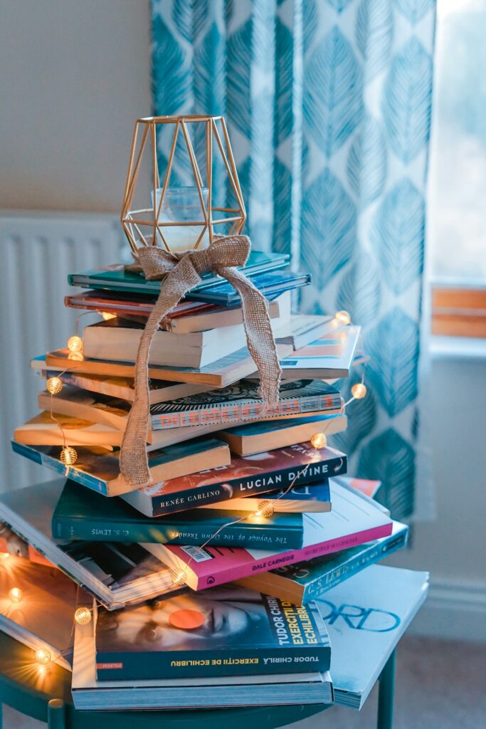 Chi siamo: pila di luci e libri sopra un tavolo